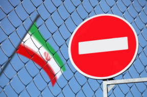 flag of Iran behind a fence with a sign is forbidden