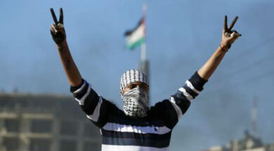 شاب-فلسطيني-يرفع-شارتي-النصر-وخلفه-العلم-الفلسطيني-بعد-مواجهات-مع-الاحتلال-في-الضفة-الغربية-ا-ف-ب